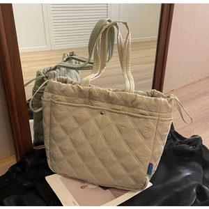 Detailed quilted beige nylon tote bag with side drawstring and front buckle pocket