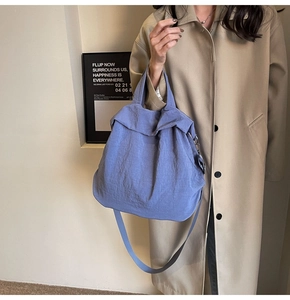 Nebelblaue Nylon-Einkaufstasche kombiniert mit einem khakifarbenen Trenchcoat-Look