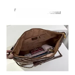 Detailed interior of quilted tote bag with golden chain strap and organized compartments