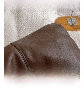 Close-up of brown faux leather tote with textured lychee grain and double-needle stitching