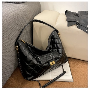 Detailed view of black quilted hobo bag with gold twist lock and chain strap