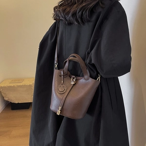 Vintage dark brown leather bucket bag with top handles and smiley charm for women