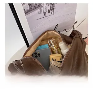 Detail shot of brown litchi leather tote interior with beige lining and zip pocket