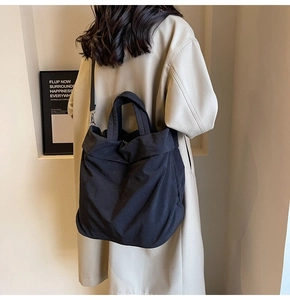 Detail-Rückansicht einer großen schwarzen Nylon-Einkaufstasche von einem Model getragen