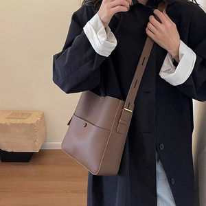 Bolso tipo cubo marrón de piel granulada con correa ajustable y bolsillo frontal