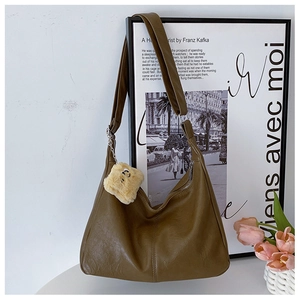 Detail of olive brown hobo bag with textured leather and a cute plush charm accessory