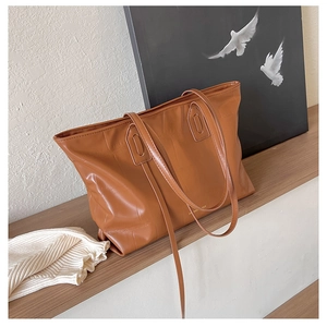 Detail of brown crocodile pattern tote bag with leather texture and double straps