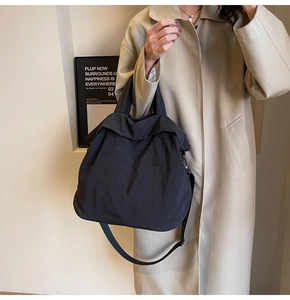 Detailansicht einer großen schwarzen Falten-Nylontasche mit abnehmbarem Umhängegurt