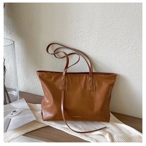 Detailed macro of brown crocodile texture leather tote bag with FASHION BAGS text