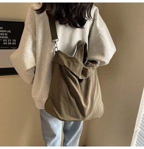 Detail der armee-grünen Nylon-Tasche mit verstellbarem Gurt an einem Modell