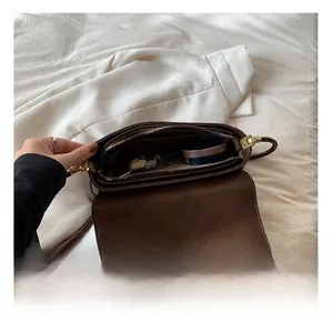 Vue intérieure de la besace vintage en cuir marron montrant sa grande capacité de rangement
