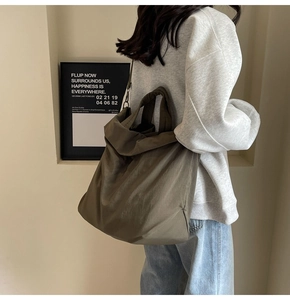 Minimalistische olivgrüne Nylon-Einkaufstasche am Modell in modernem Ambiente