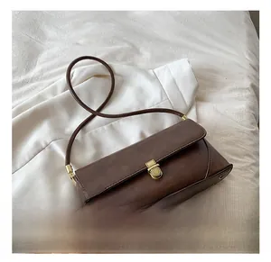 Détail du sac à bandoulière en similicuir marron foncé avec boucle dorée vintage