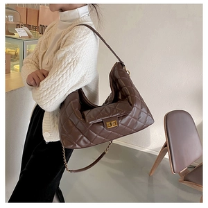 Close-up of brown quilted leather tote bag featuring gold twist lock and chain strap