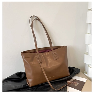 Detailed view of brown tote bag with faux crocodile texture and interior lining