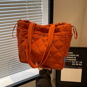 Quilted nylon tote bag in bright orange with diamond stitching and drawstring closure