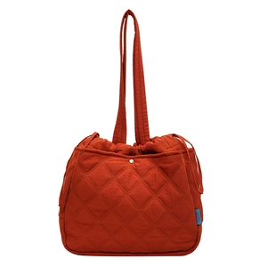 Rust red quilted canvas drawstring tote bag with elegant diamond pattern and shoulder strap