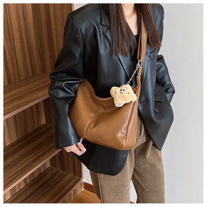 Brown faux leather tote bag detail with plush star charm and silver hardware clasp