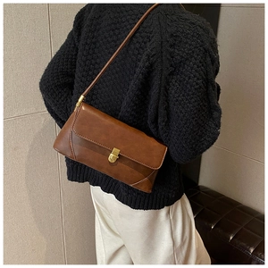 Détail du sac porté épaule marron vintage avec fermoir doré et texture en similicuir chic