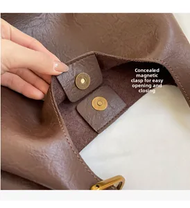 Détail du fermoir magnétique en bronze et texture grainée du sac cabas marron