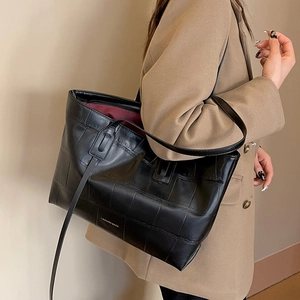 Large capacity black crocodile embossed tote bag with slim shoulder strap worn on shoulder
