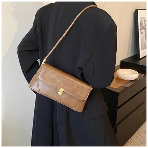 Détail du sac porté épaule vintage marron avec fermoir doré sur cuir synthétique