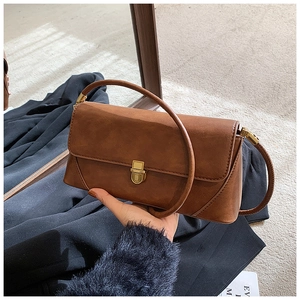Gros plan d'un sac sous les bras en cuir marron rétro avec fermoir en métal doré vintage