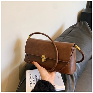 Détail d'un sac à main en cuir marron foncé mat avec fermoir à poussoir doré vintage