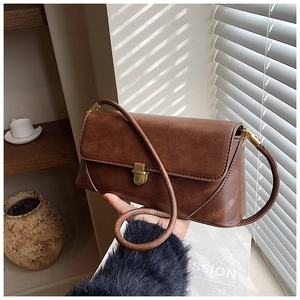 Détail d'un sac sous les aisselles en cuir marron vintage avec fermoir rotatif doré