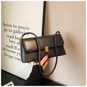 Détail d'un sac sous le bras en cuir noir vintage avec un fermoir en métal doré classique