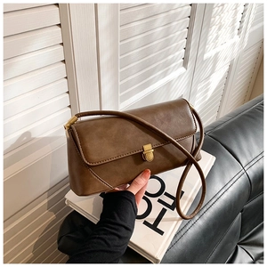 Gros plan d'un sac à main marron vintage avec fermoir doré sur fond minimaliste moderne