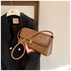 Détail du sac à bandoulière en cuir marron vintage avec boucle en métal et poignée