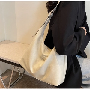 Détail du sac cabas blanc cassé en cuir PU grainé avec plaque métallique de marque