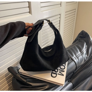 Detail of black matte suede hobo bag with golden adjustable buckle and zip closure