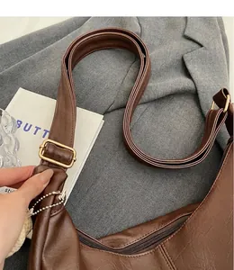 Detalle de correa ajustable con hebilla dorada en bolso tote marrón estilo vintage