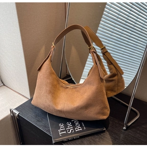 Detail of vintage brown suede hobo bag featuring adjustable strap and golden metal buckle