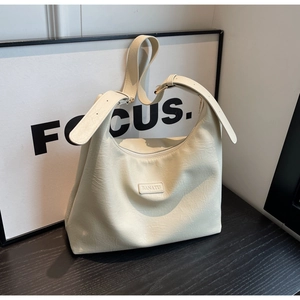 Gros plan du sac hobo blanc crème avec logo minimaliste et texture en similicuir