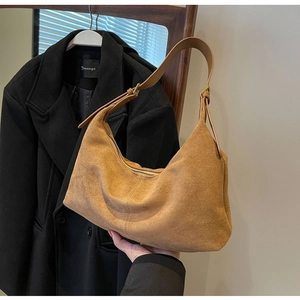 Detail view of brown suede hobo bag featuring adjustable strap and gold metal hardware