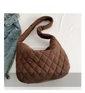 Detail view of brown corduroy tote bag featuring a diamond quilted pattern texture