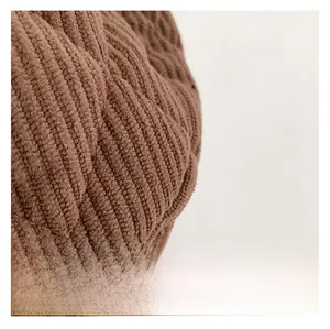 Macro view of brown corduroy fabric featuring quilted diamond pattern stitching