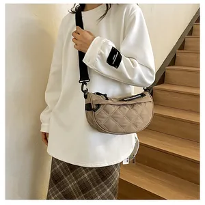 Close-up of khaki quilted half-moon crossbody bag with wide adjustable shoulder strap