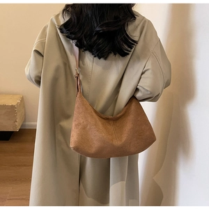 Detail of dark brown matte suede hobo bag with exquisite double stitching and long strap