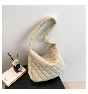 Detail of cream corduroy hobo bag showing quilted diamond pattern and soft texture