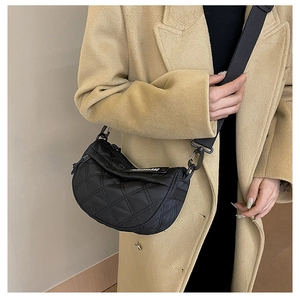 Detail of black quilted nylon half-moon crossbody bag with wide shoulder strap