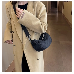 Close-up of black quilted nylon half-moon bag with elegant diamond stitching details