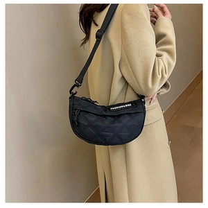 Detail of black quilted crescent crossbody bag with adjustable strap and fashion logo