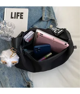 Internal view of a black nylon crossbody bag showing spacious storage for a tablet and items