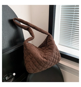 Close-up of brown corduroy quilted tote bag showing detailed ribbed texture on wooden chair
