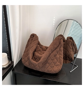 Detail of dark brown quilted corduroy tote bag showing soft rhombic texture and plush finish