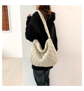 Detail of large beige corduroy quilted tote bag showing texture and crossbody strap